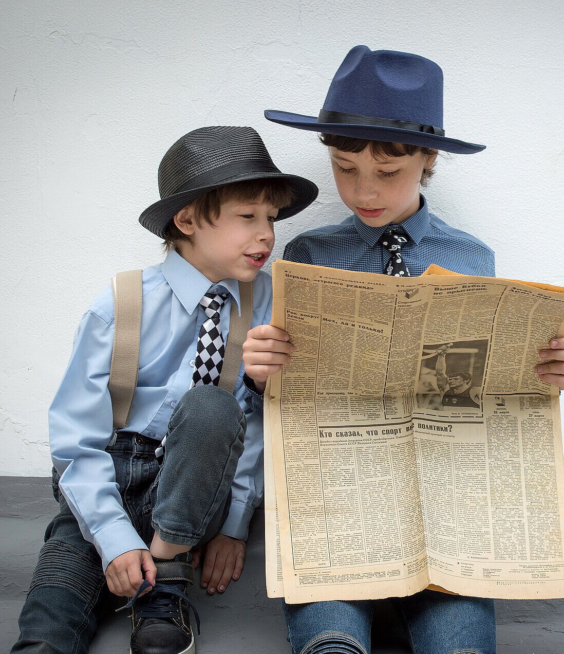 zwei kleine Jungs lesen Zeitung